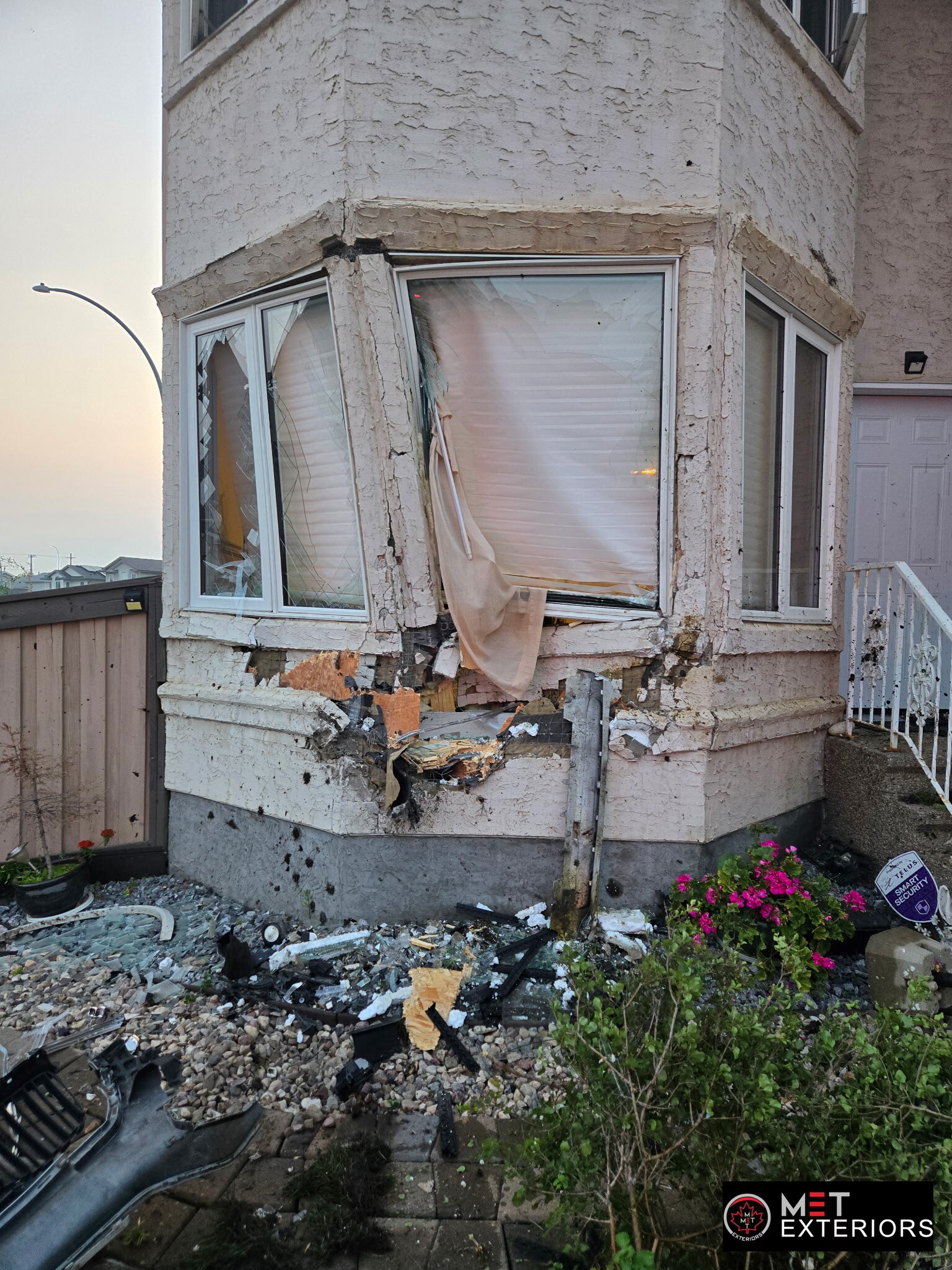 Exterior Construction & Renovation Blog – Edmonton, Alberta 1 Close view of vehicle collision damage to stucco, sheathing and a bay window before insurance restoration