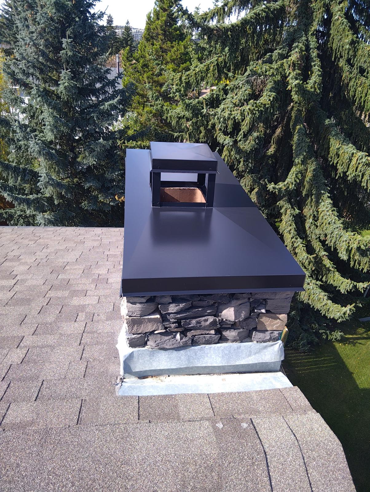 After: completed exterior stone chimney with protective metal cap