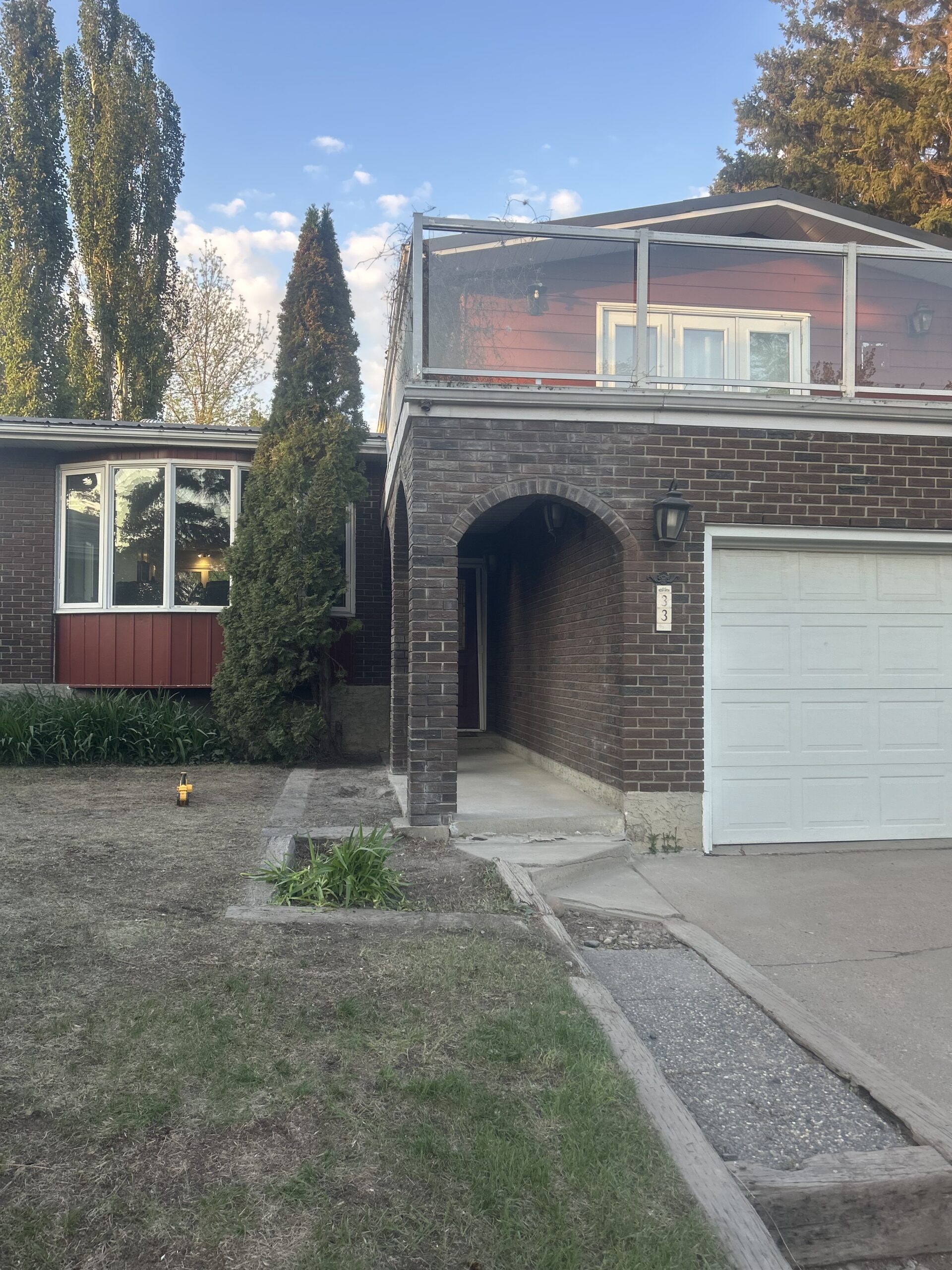 Residential brick entrance with decorative masonry arch and column before restoration